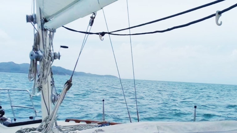 white boat sailing in the middle of the ocean