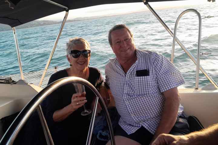 a man and woman sitting next to a body of water